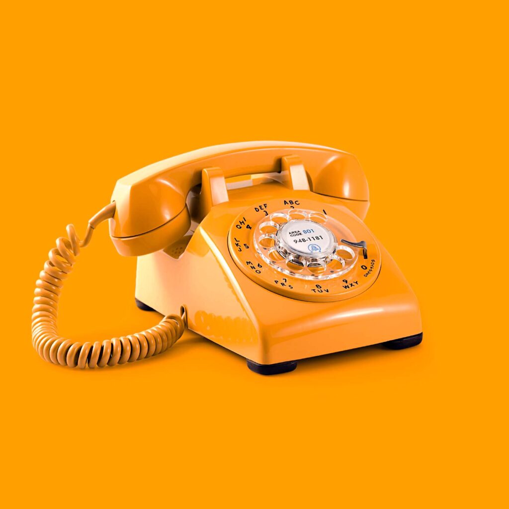 orange rotary phone on an orange background