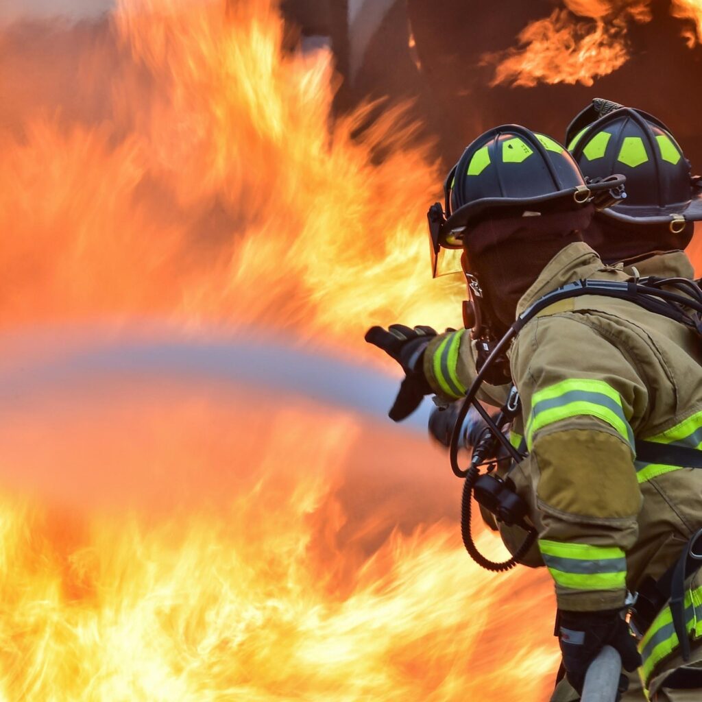 two firefighters putting out a fire with water